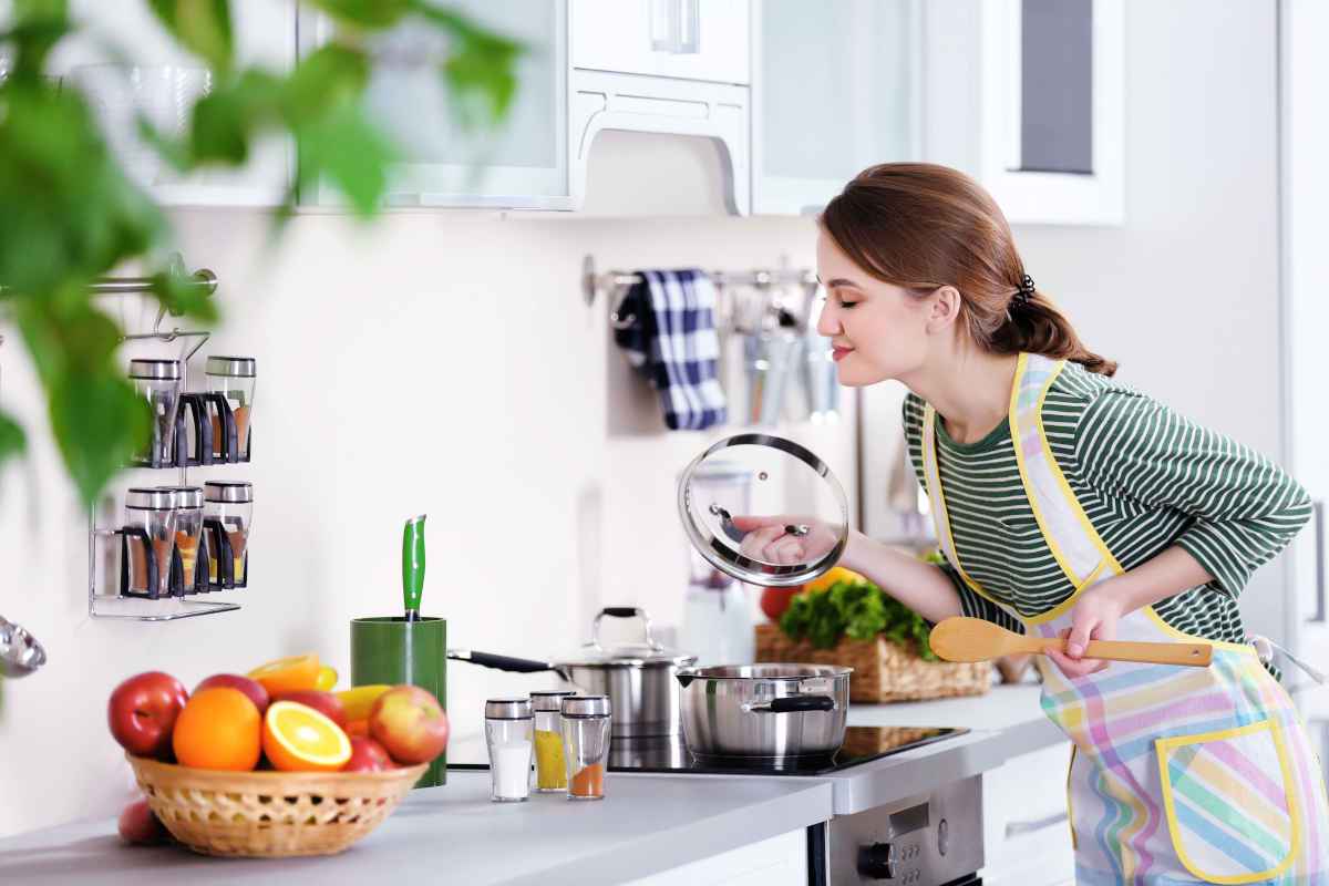 donna annusa il profumo del cibo in pentola