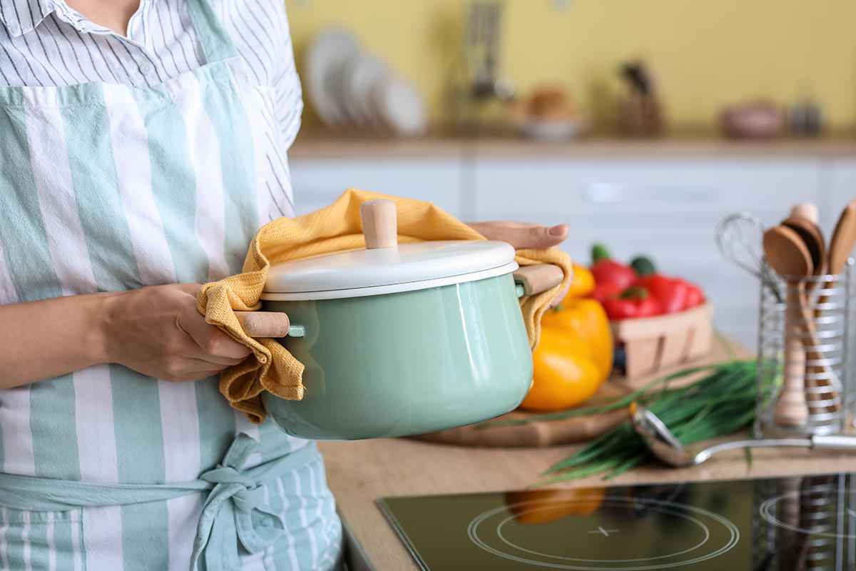 Donna che cucina su di un piano di cottura a induzione