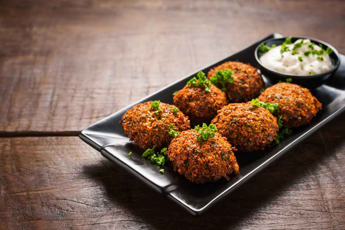 vassoio rettangolare nero con falafel e salsa tzatziki