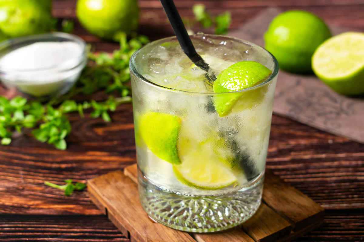 bicchere con cocktail caipiroka e tagliaere con stuzzichini