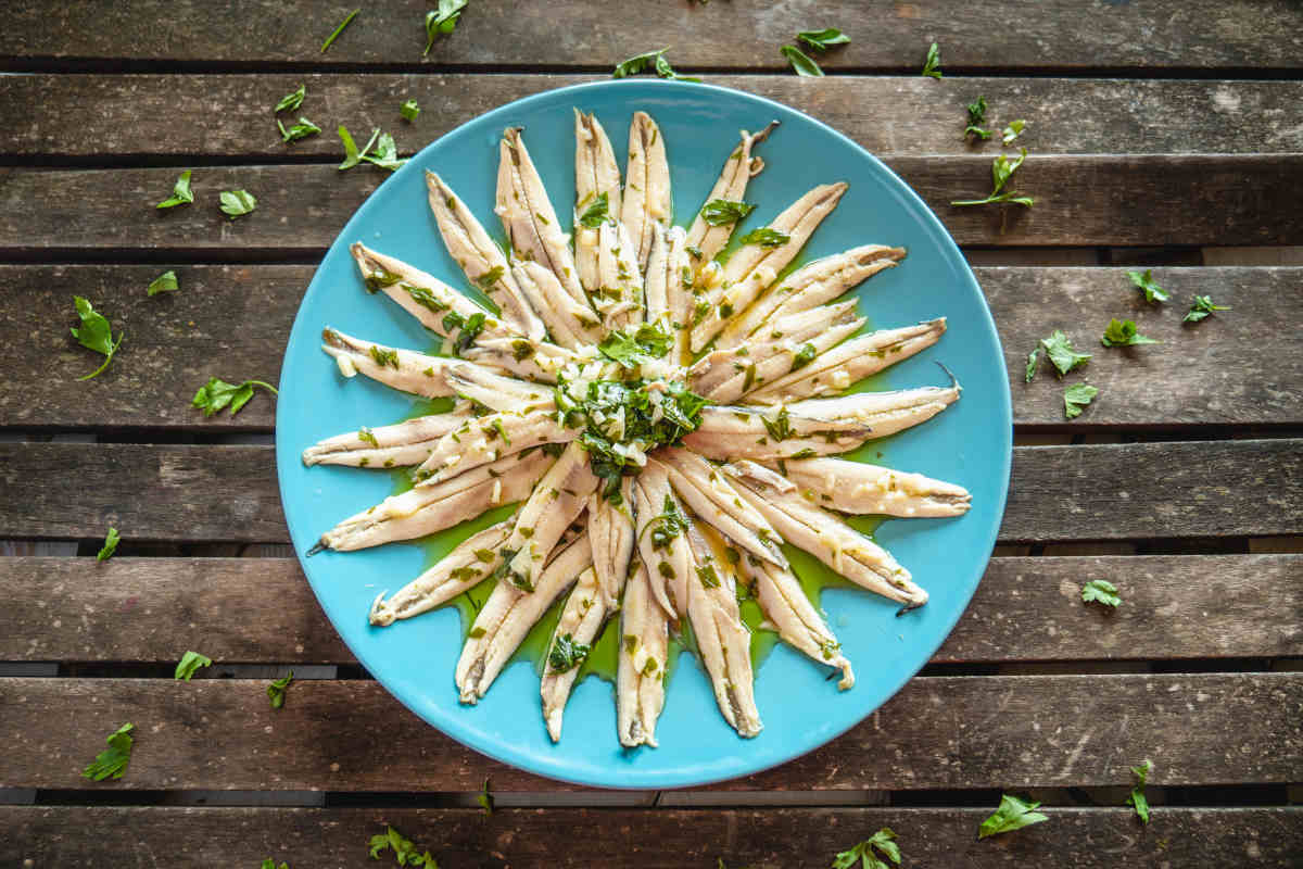 piatto azzurro con filetti di alici marinate