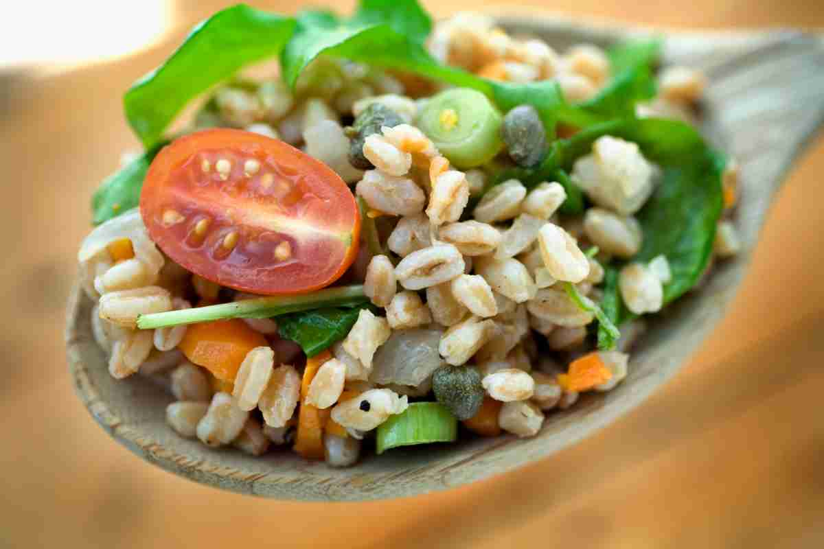 insalata di farro in un cucchiaio di legno come esempio di come cucinare il farro