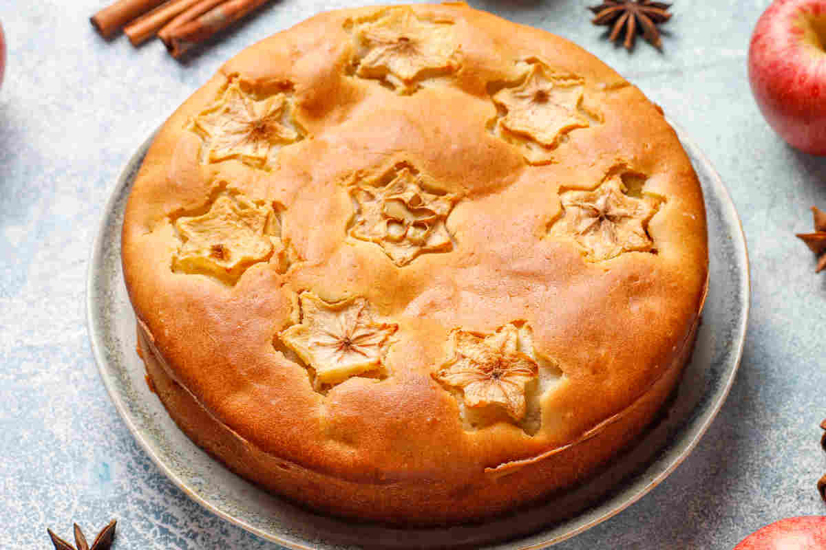 Torta di mele vista dall'alto con guarnizione di fette di mela tagliate a forma di stelle