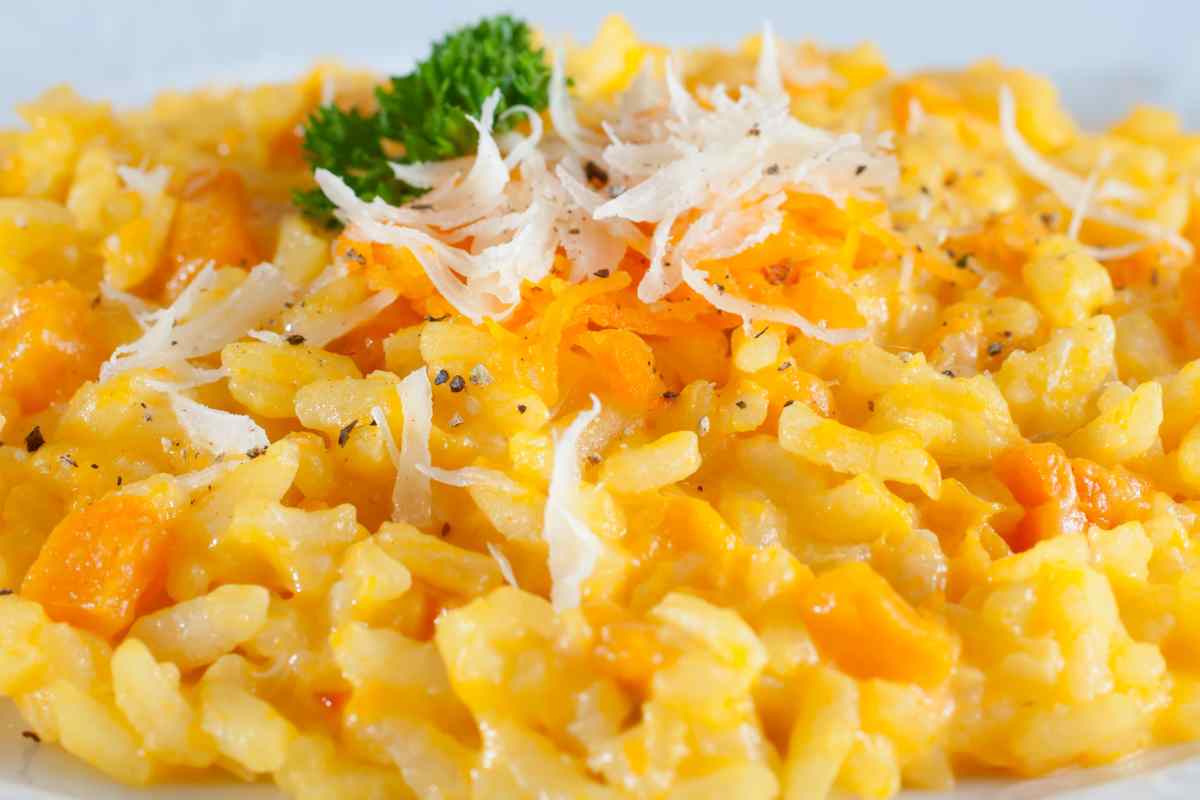 Risotto alla zucca guarnito con formaggio grattugiato e pepe nero