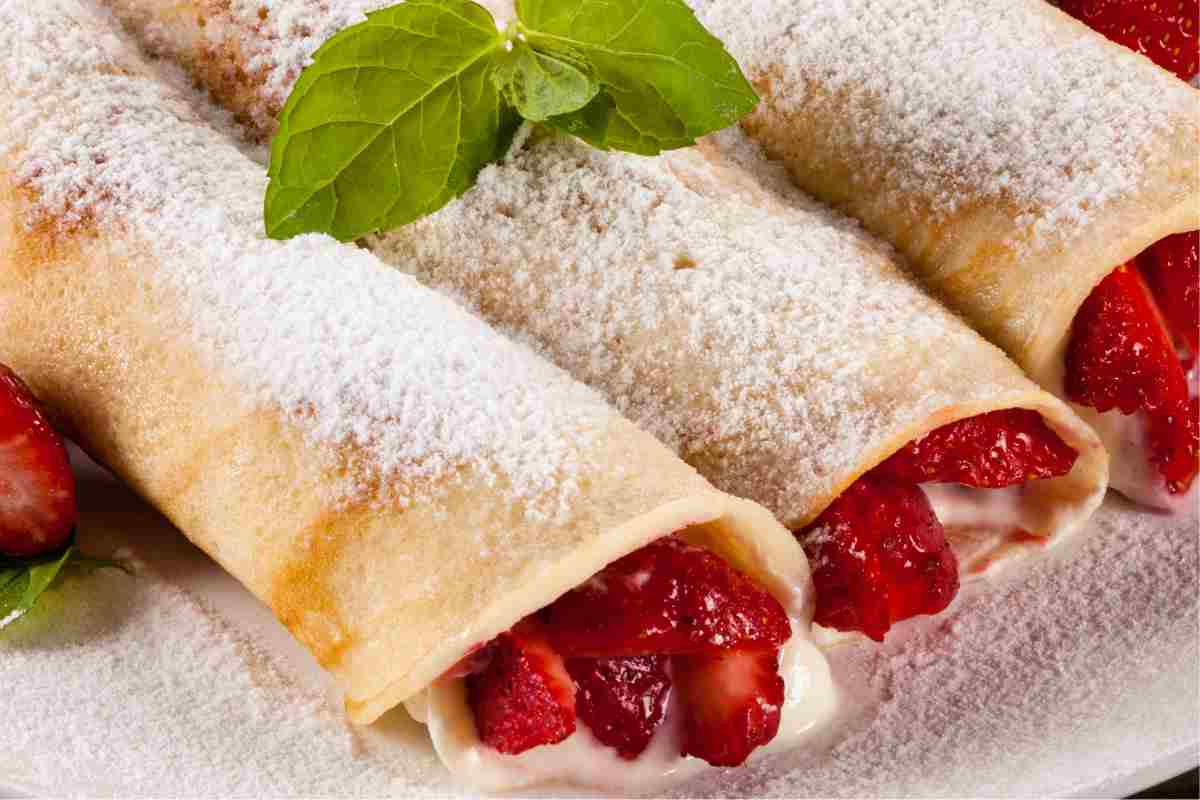 Crepes crema e fragole arrotolate con zucchero a velo sopra