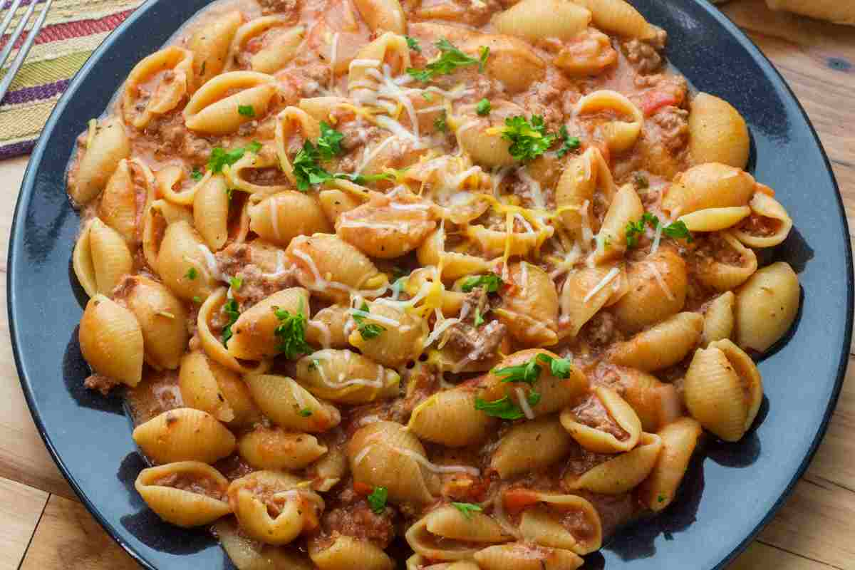 Gnocchetti sardi con ragù di salsiccia in un piatto blu