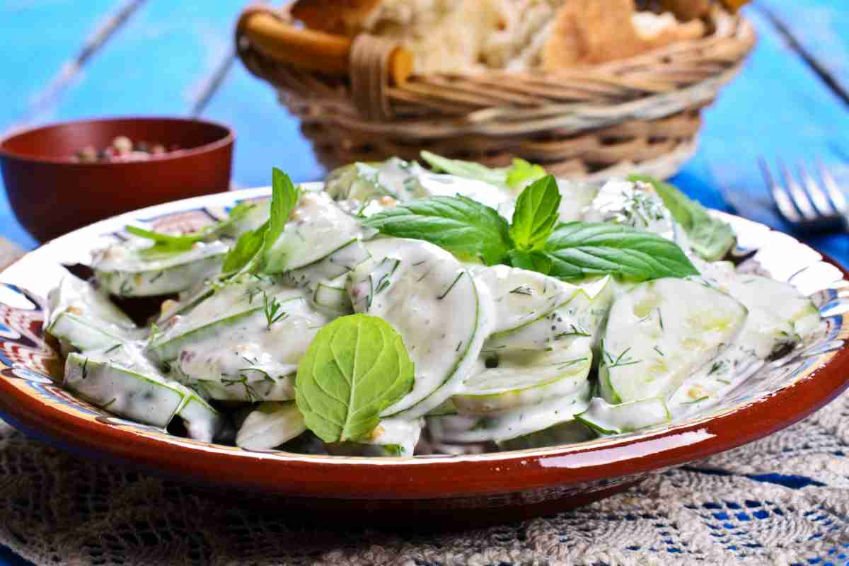 Insalata di cetrioli e yogurt in piatto rosso