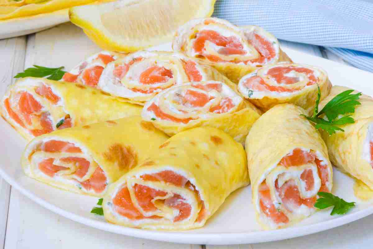 Rotoli di frittata salmone e philadelphia in un piatto bianco