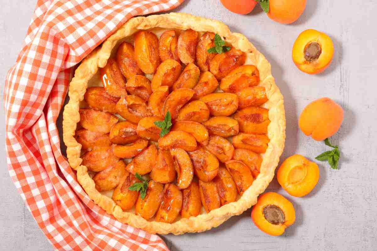 Crostata di albicocche con frutta fresca e canovaccio rosso