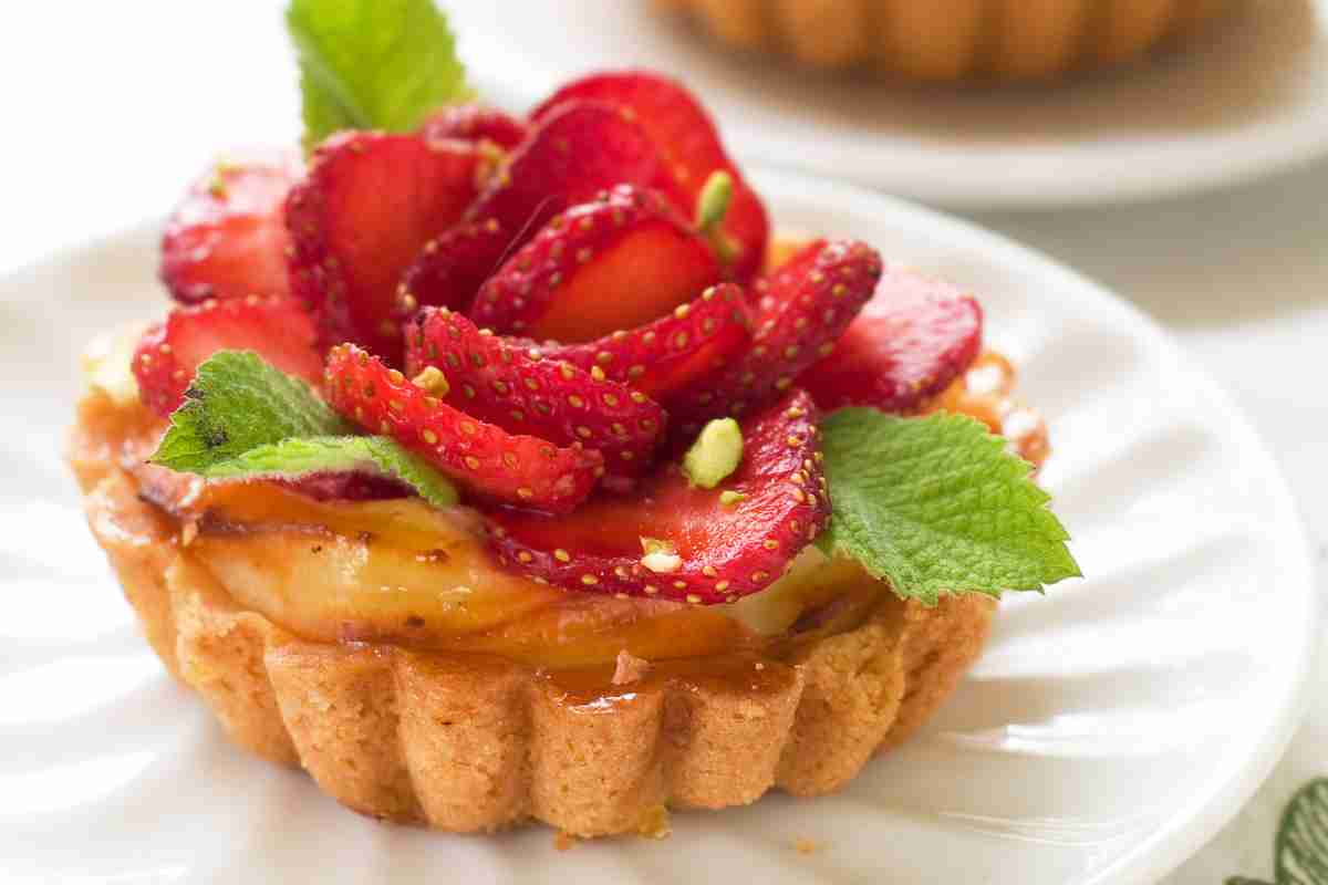 Crostata di ricotta e fragole monoporzione con foglioline di menta per decorazione