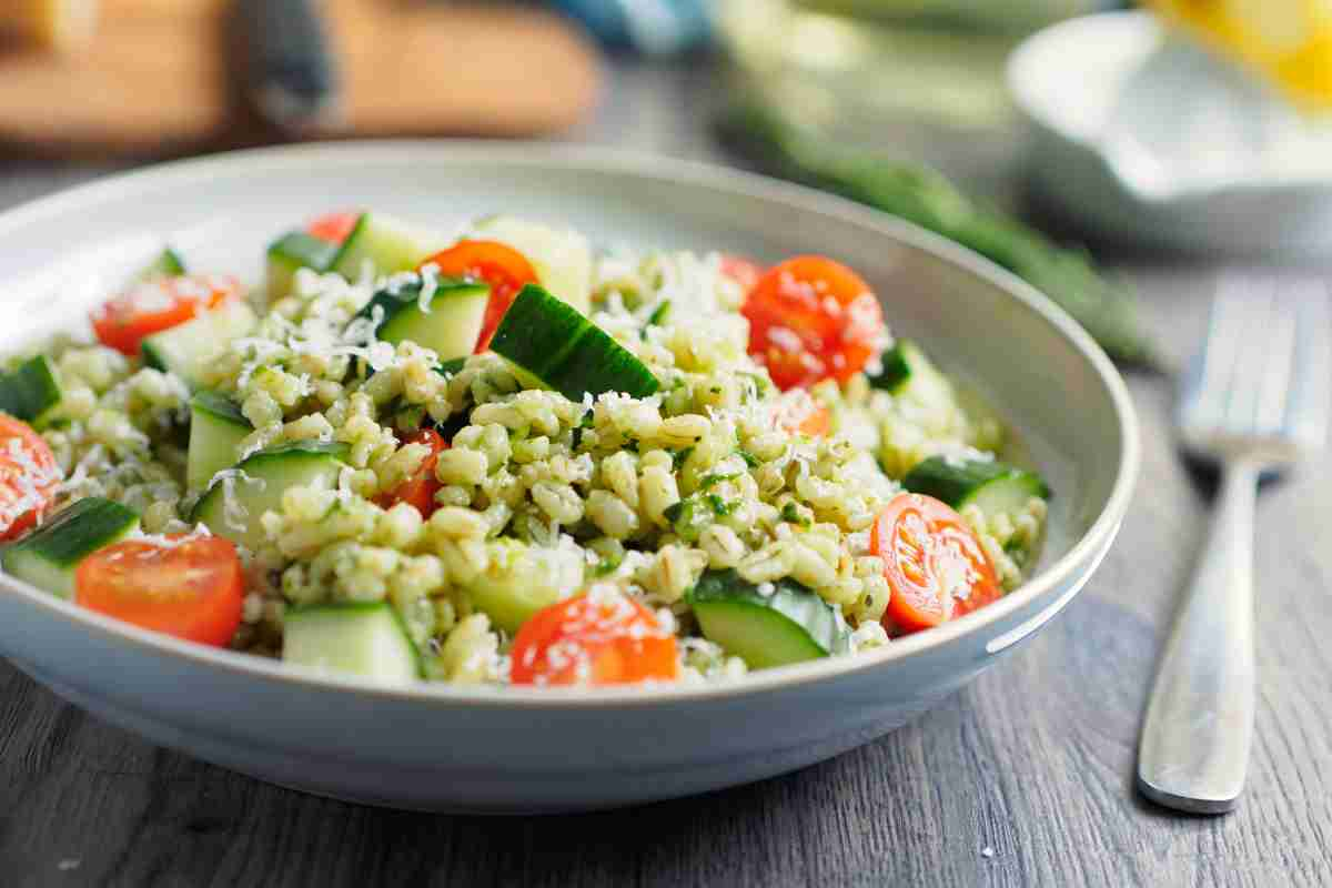 piatto grigio con insalata di orzo zucchine e pomodori