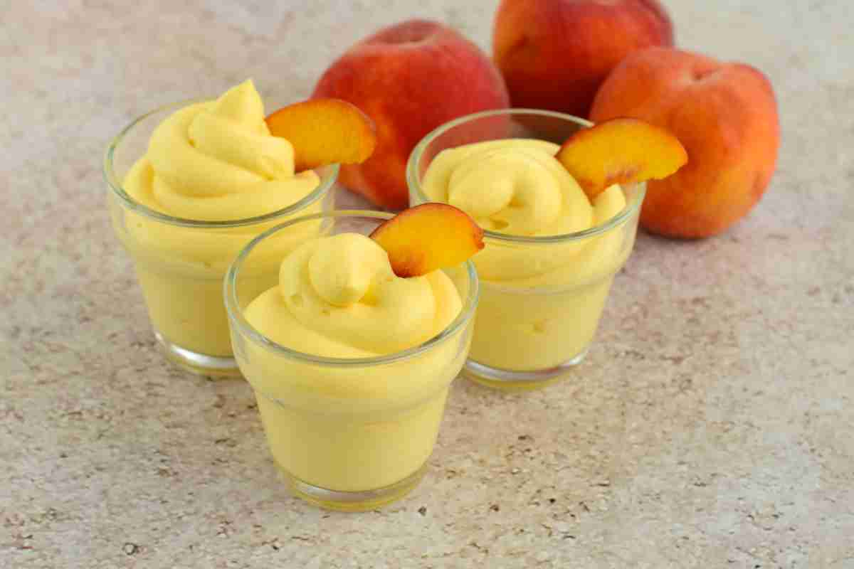 Mousse di pesche in bicchierini decorati con pezzi di frutta