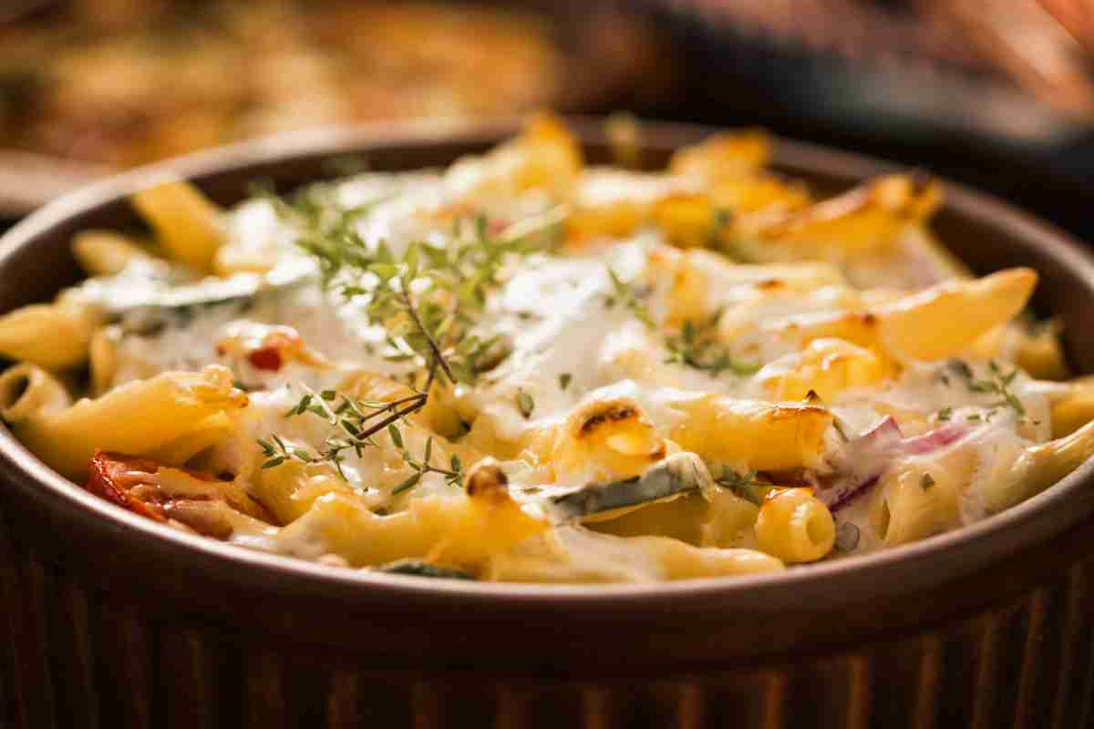 Pasta gratinata con verdure in una terrina con sopra foglie di timo