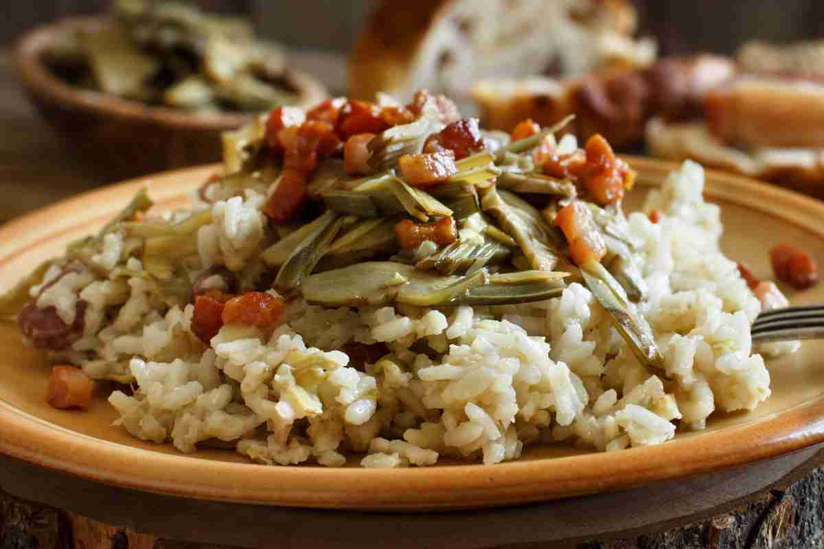 Risotto carciofi e pancetta in piatto piano color marrone