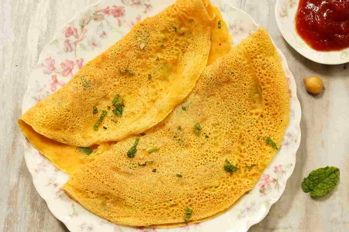 Crespelle salate senza glutine con farinata di ceci in un piatto con vicino una ciotola di salsa