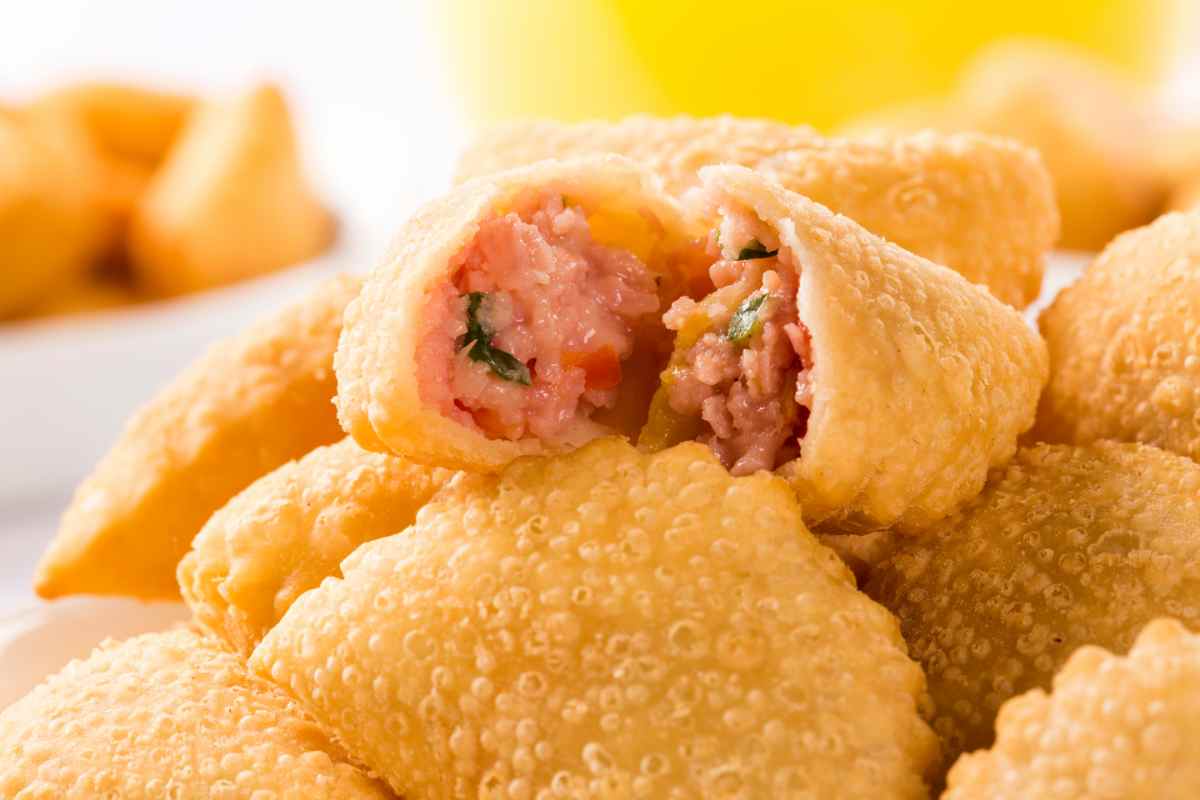 Mezzelune fritte aperte in cui si vede il ripieno di prosciutto e formaggio