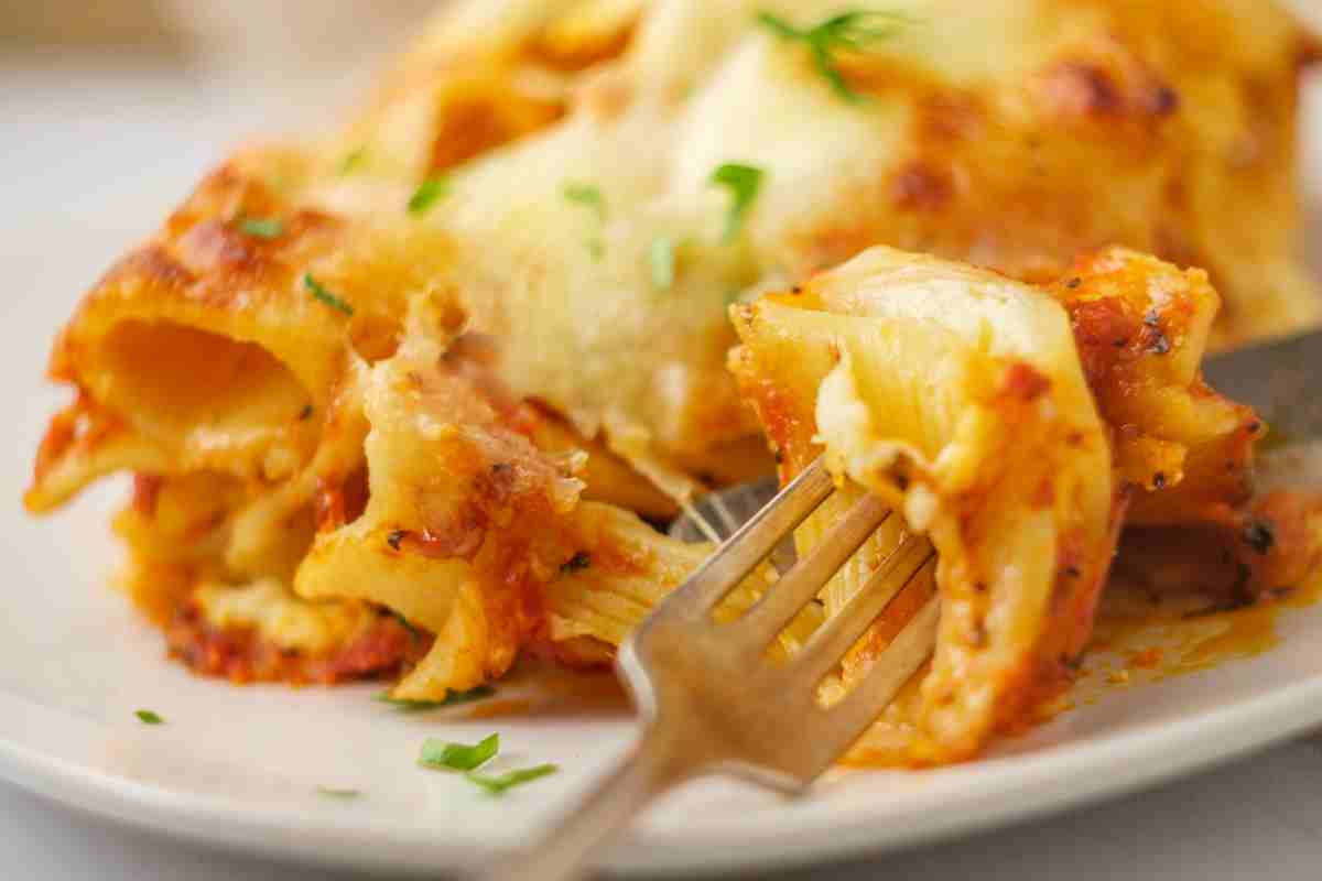 Pasta al forno in un piatto con forchetta infilzata