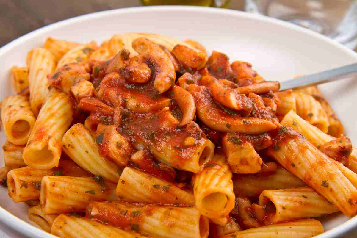 Pasta con i moscardini in un piatto con la forchetta dentro