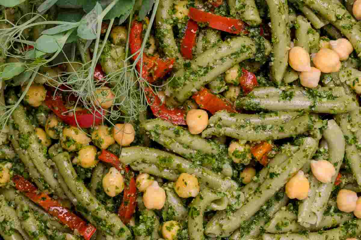 Pasta verde fredda condita con pesto, pomodori e ceci