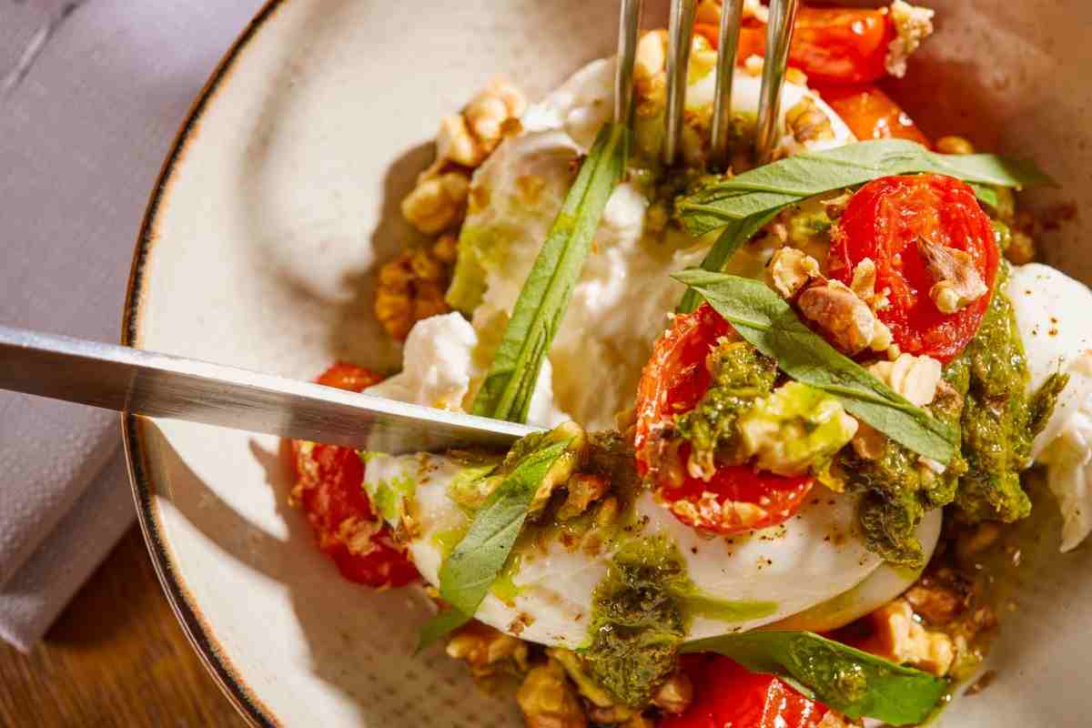 piatto di caprese con burrata e pesto