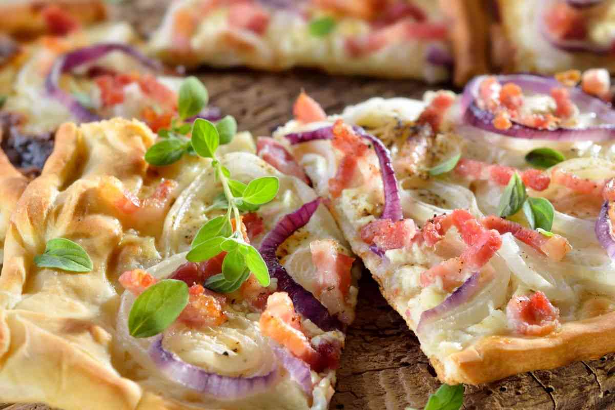 tranci di pizza in teglia farcita con cipolle e pancetta