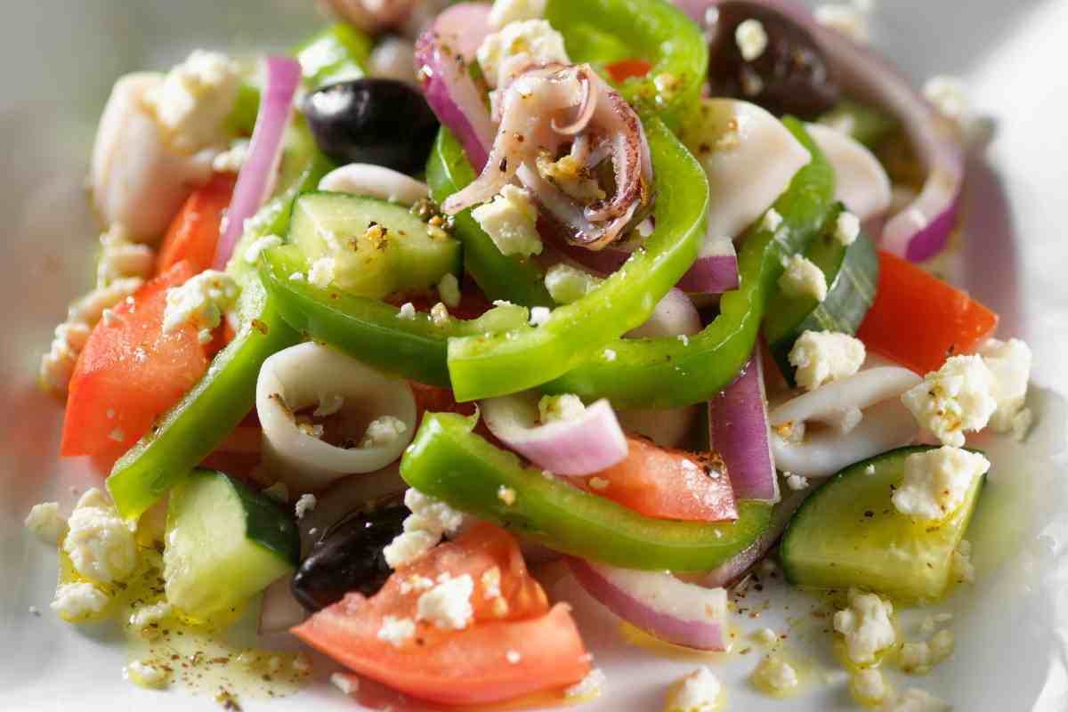 Insalata di calamari con pomodori, olive, cipolle, peperoni, cetrioli e feta