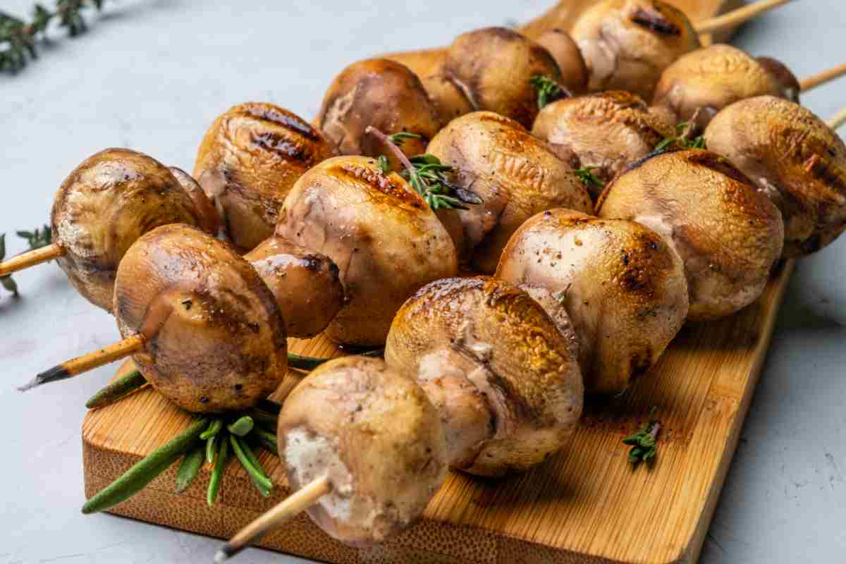 Spiedini di funghi su un tagliere per la ricetta del giorno