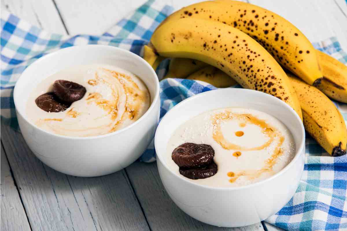 Fruttolo alla banana in due ciotole con frutti maturi sullo sfondo