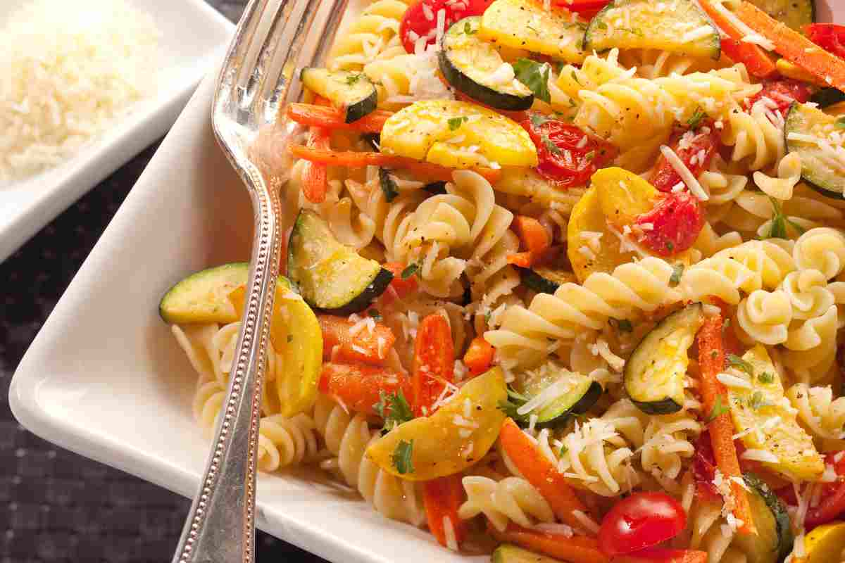 Insalata di pasta con zucchine e mix di pomodorini in un piatto