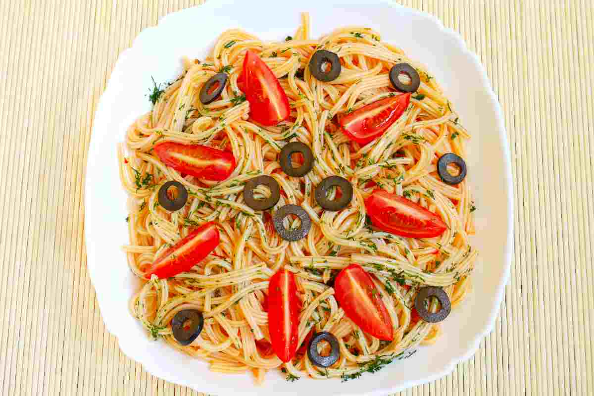 Pasta alla gaetana con olive alici e pomodori in un piatto