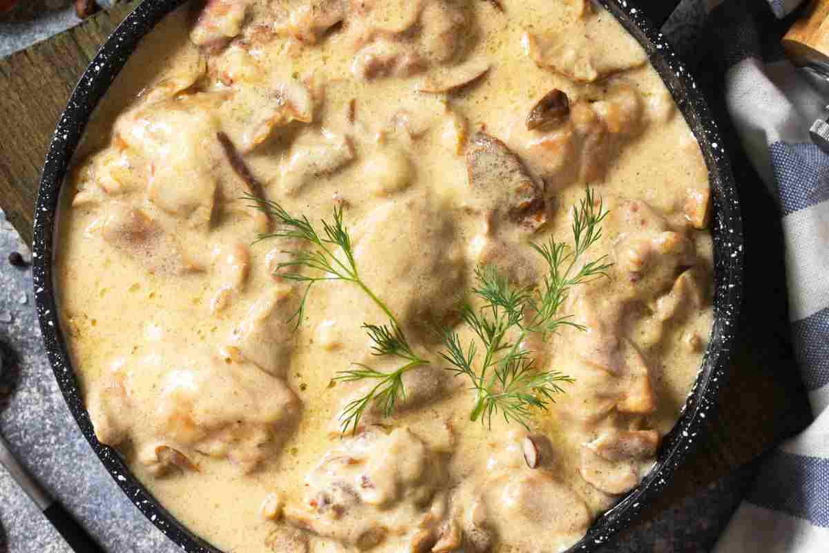 Pollo con panna e funghi congelati in una padella vista dall'alto